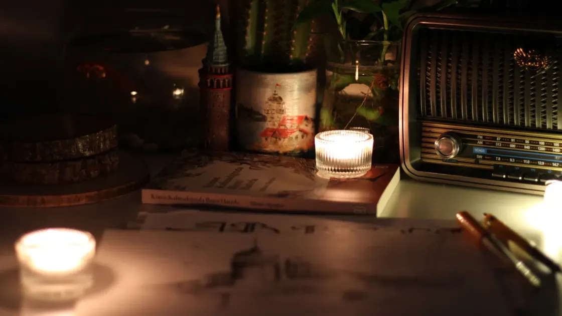 Radio och tända ljus på ett bord i ett mörkt rum