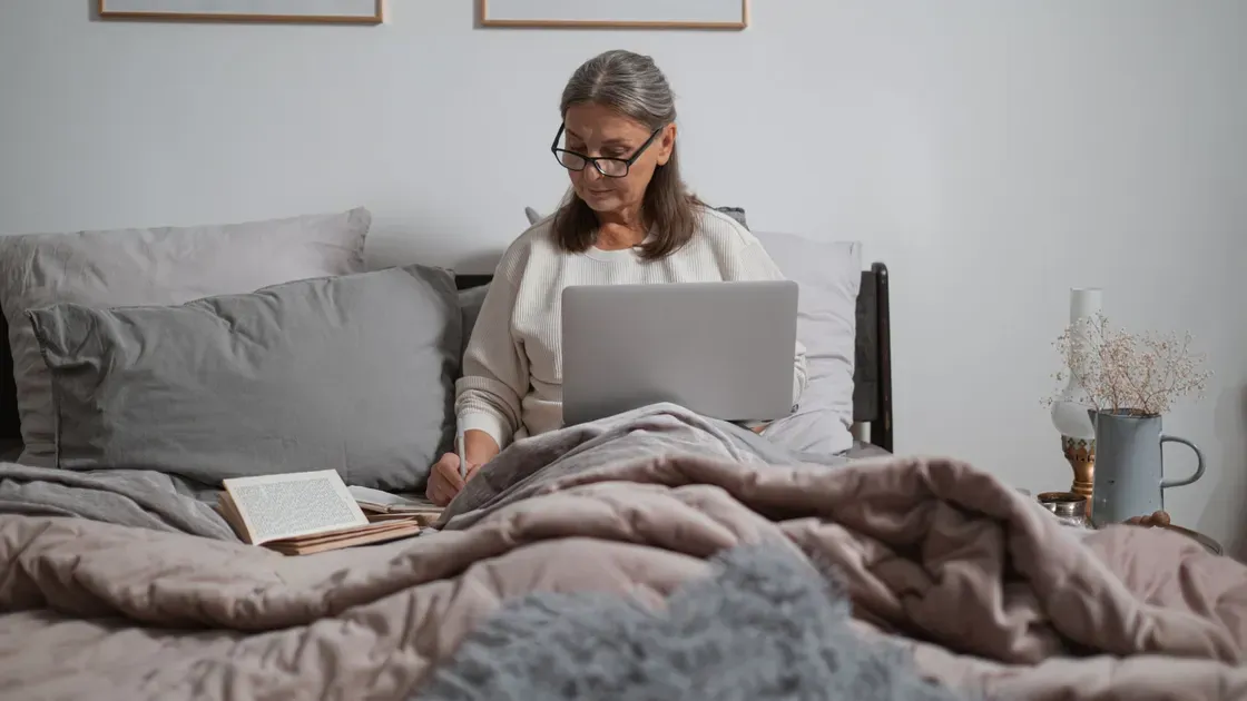Uppbäddad säng med höjd huvudända i ett ljust sovrum