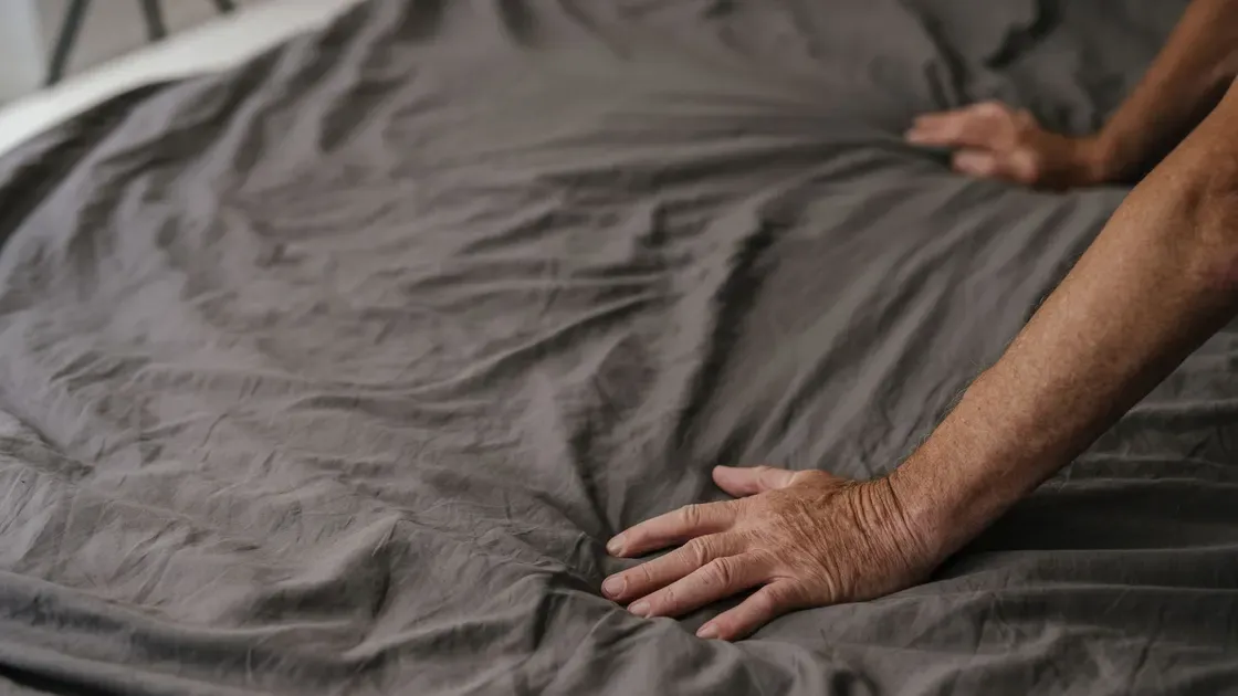 Uppbäddad säng med vitt linne i ett ljust sovrum